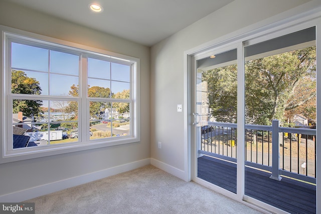 doorway to outside with light carpet and a wealth of natural light