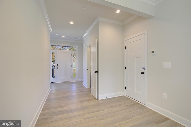 corridor with ornamental molding and light hardwood / wood-style flooring