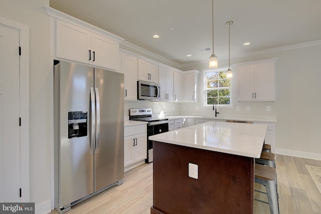 kitchen with white cabinetry, light hardwood / wood-style floors, appliances with stainless steel finishes, and pendant lighting