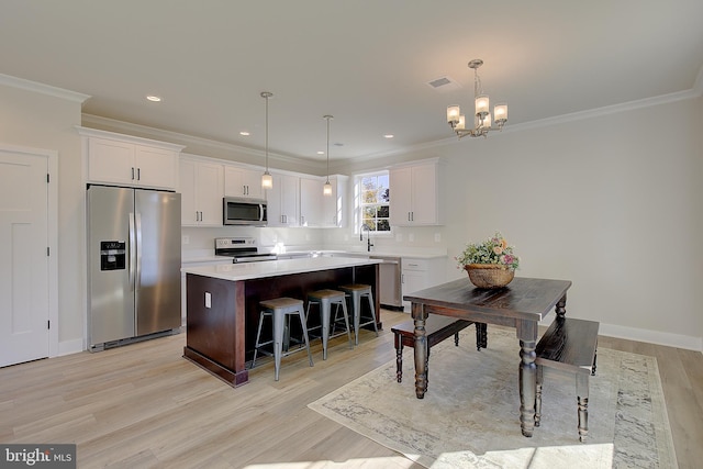 kitchen featuring light hardwood / wood-style floors, appliances with stainless steel finishes, a center island, and white cabinets