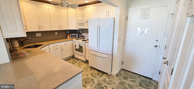 kitchen featuring sink, white cabinets, and white appliances