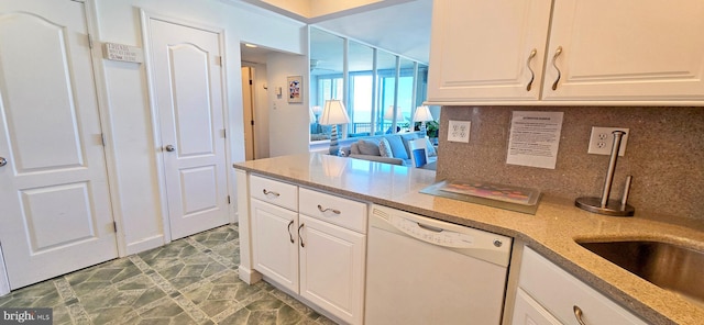 kitchen with decorative backsplash, white dishwasher, and white cabinetry