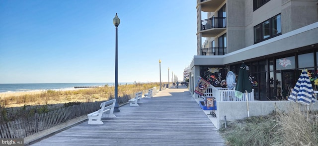 view of dock featuring a beach view and a water view