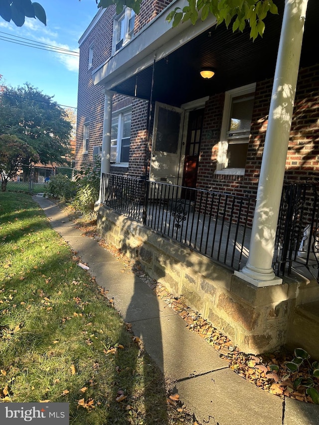 view of side of home featuring covered porch