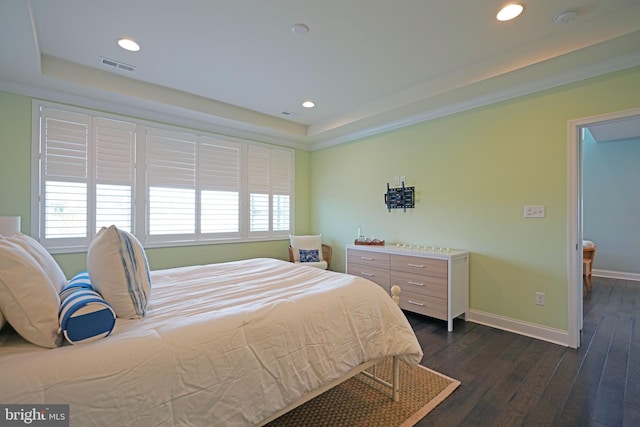 bedroom with dark hardwood / wood-style flooring and a raised ceiling