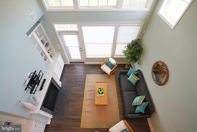 living room featuring dark hardwood / wood-style floors and a towering ceiling