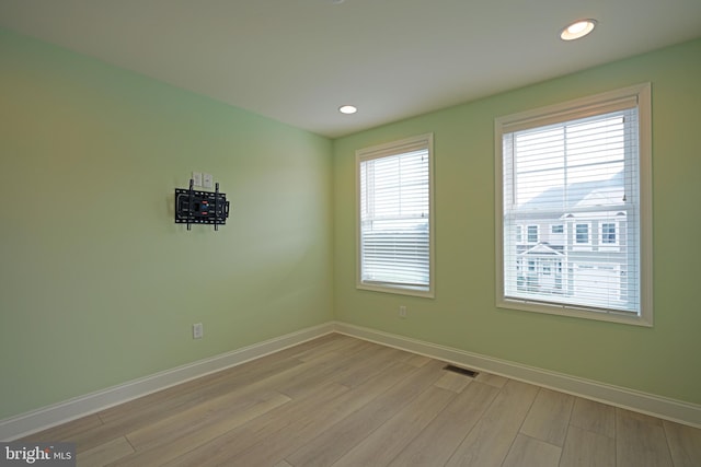 unfurnished room featuring a wealth of natural light and light hardwood / wood-style floors