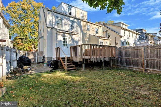 back of house with a yard, cooling unit, and a wooden deck