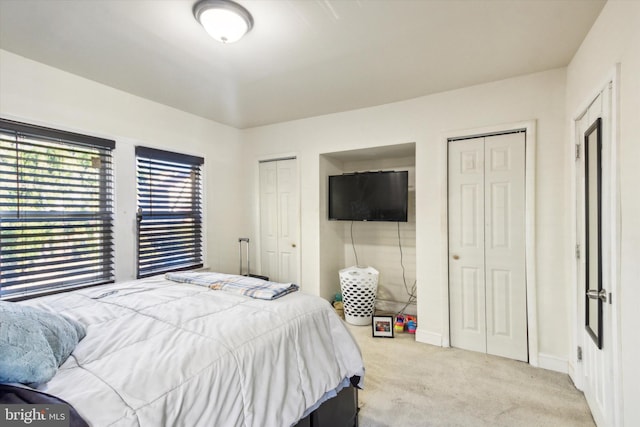 carpeted bedroom with multiple closets