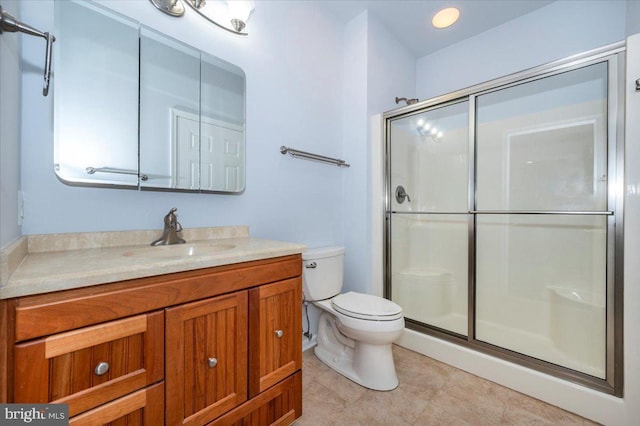 bathroom with vanity, toilet, and a stall shower