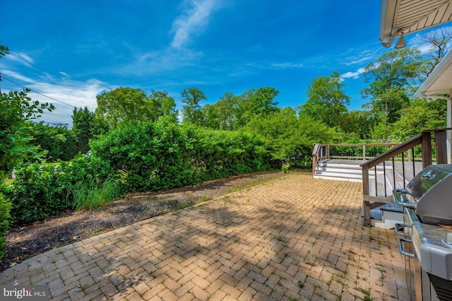 view of patio with a grill, stairway, and a wooden deck