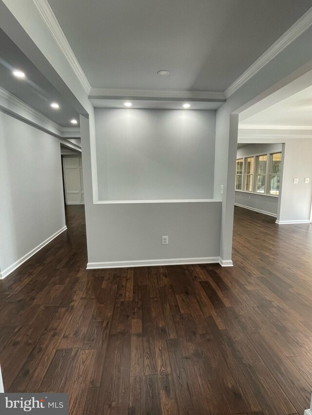 empty room with crown molding, recessed lighting, baseboards, and wood finished floors