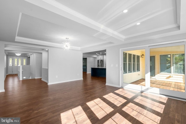 unfurnished living room featuring a notable chandelier, plenty of natural light, and dark wood-type flooring