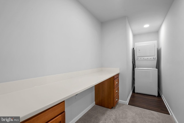 interior space featuring dark carpet and stacked washer / dryer