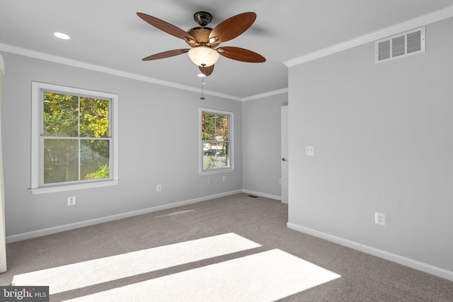 empty room featuring ceiling fan, light colored carpet, and ornamental molding