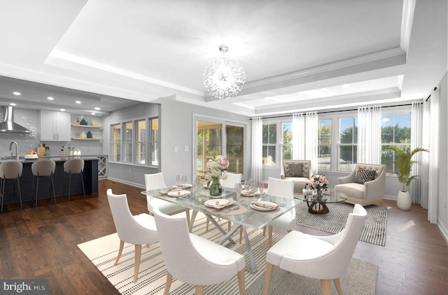 dining space with a tray ceiling, a notable chandelier, crown molding, dark wood finished floors, and recessed lighting