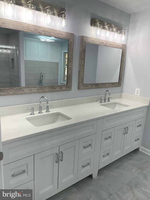 full bathroom featuring a sink, double vanity, a shower stall, and marble finish floor