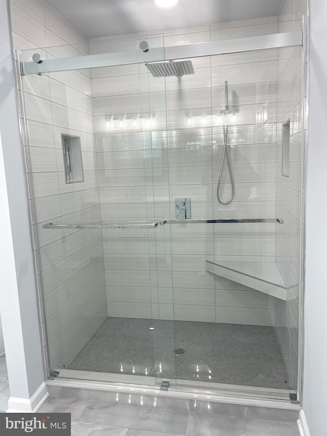 full bathroom featuring baseboards and a shower stall