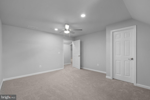 unfurnished bedroom with ceiling fan, light colored carpet, and vaulted ceiling