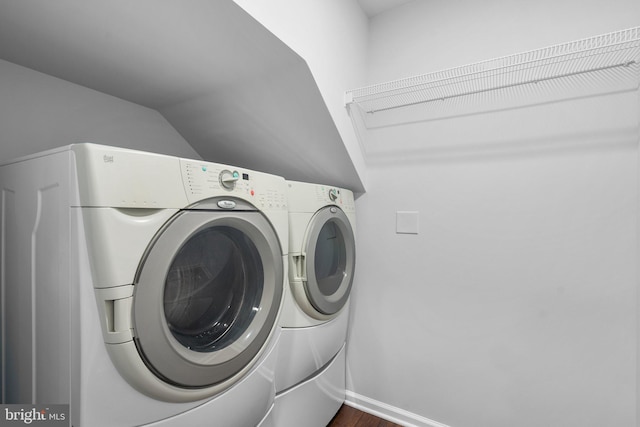 clothes washing area with dark hardwood / wood-style floors and washing machine and clothes dryer