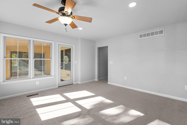 carpeted empty room featuring baseboards, visible vents, and recessed lighting