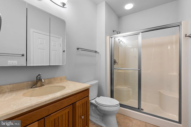 bathroom featuring tile patterned floors, a shower with door, vanity, and toilet