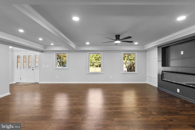 unfurnished living room with dark hardwood / wood-style flooring, ornamental molding, a raised ceiling, ceiling fan, and a fireplace