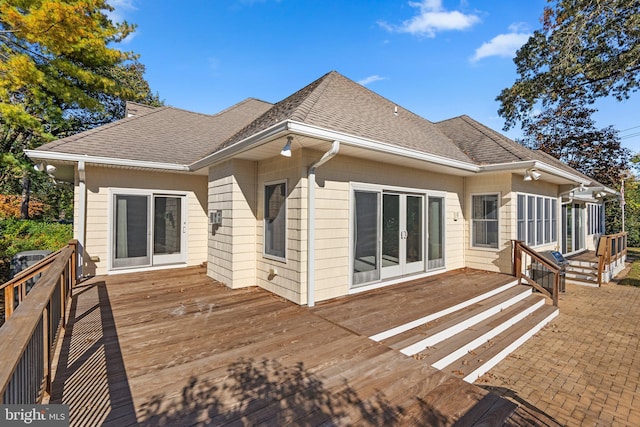back of property with a deck, french doors, and a shingled roof