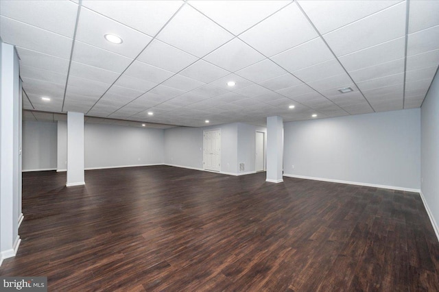 finished below grade area with baseboards, dark wood-type flooring, and recessed lighting