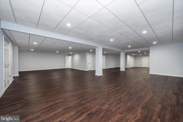 finished basement featuring wood finished floors, baseboards, and a paneled ceiling