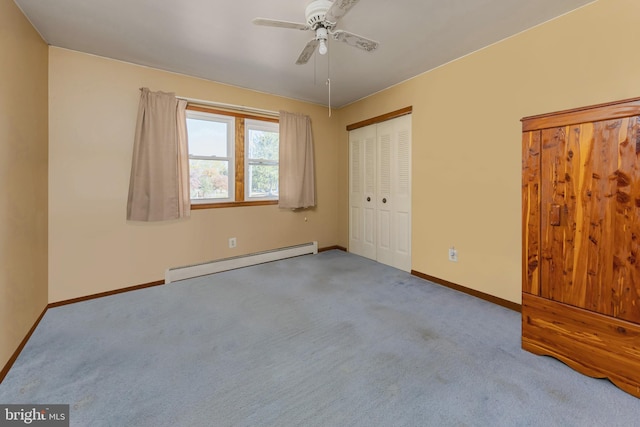 unfurnished bedroom featuring a closet, a baseboard heating unit, light colored carpet, and ceiling fan