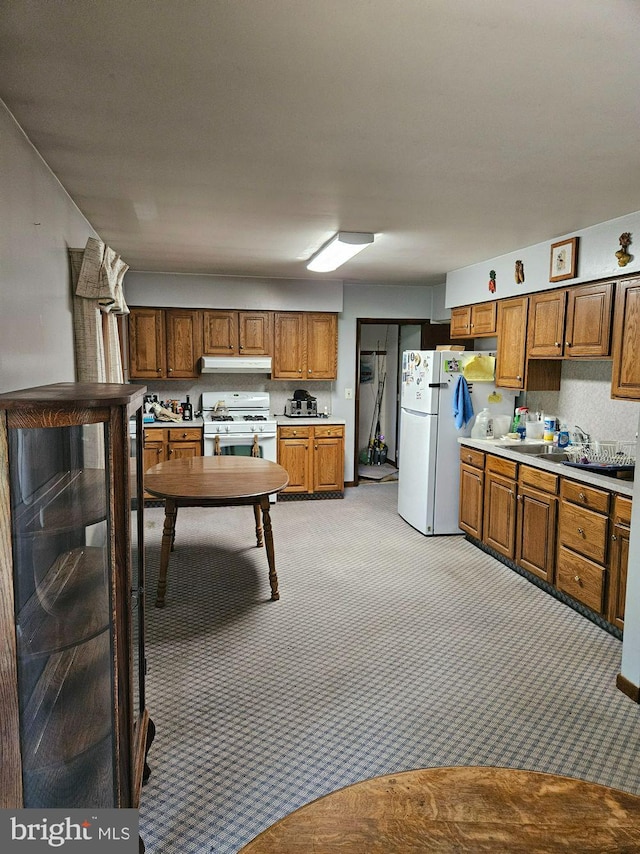 kitchen featuring light colored carpet and white appliances