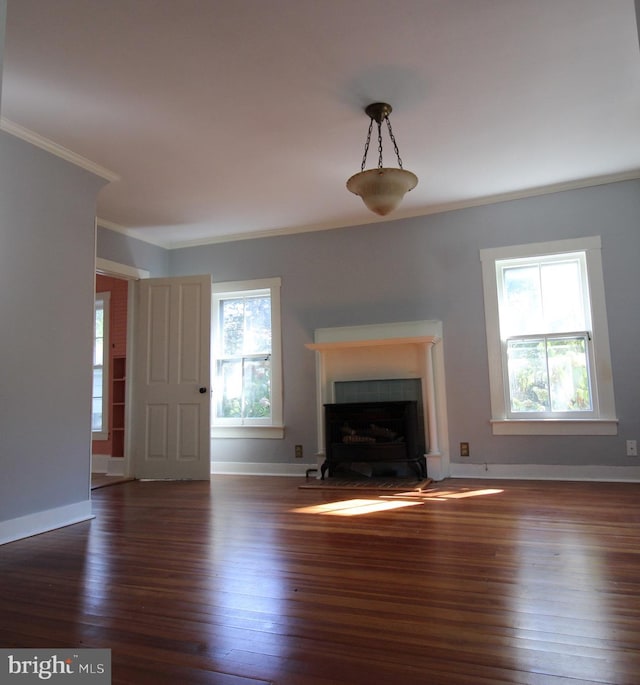 unfurnished living room featuring crown molding, dark hardwood / wood-style floors, and a healthy amount of sunlight