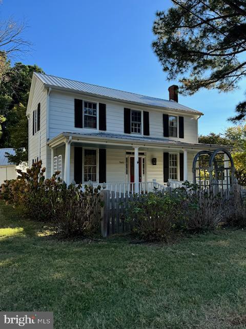 view of front of home with covered porch and a front lawn