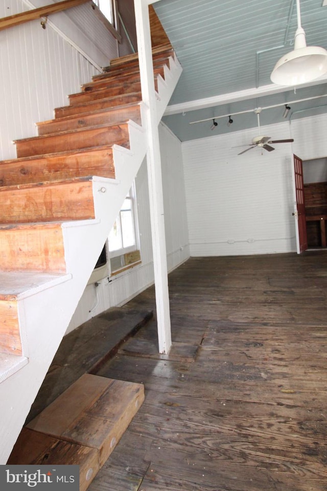 interior space with wooden walls, hardwood / wood-style flooring, and ceiling fan