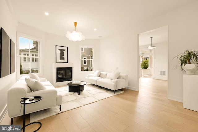 living room with light wood-type flooring and a chandelier