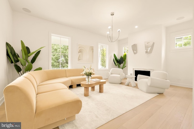 living room with light hardwood / wood-style floors and a chandelier