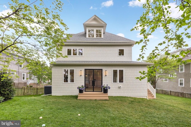 rear view of property featuring central AC and a yard