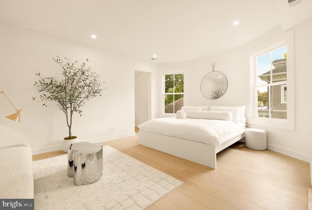 bedroom featuring multiple windows and light wood-type flooring