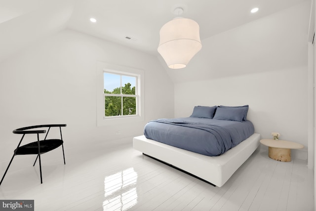 bedroom with light hardwood / wood-style floors and lofted ceiling