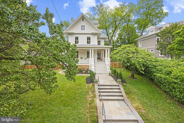 view of front of house featuring covered porch and a front yard