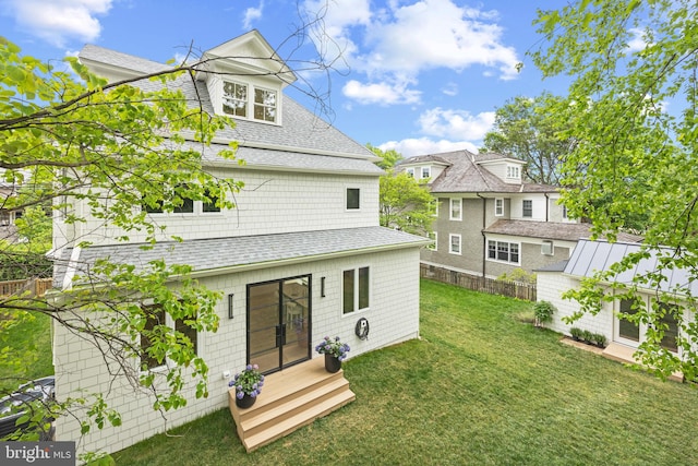 back of property with a yard and an outdoor structure