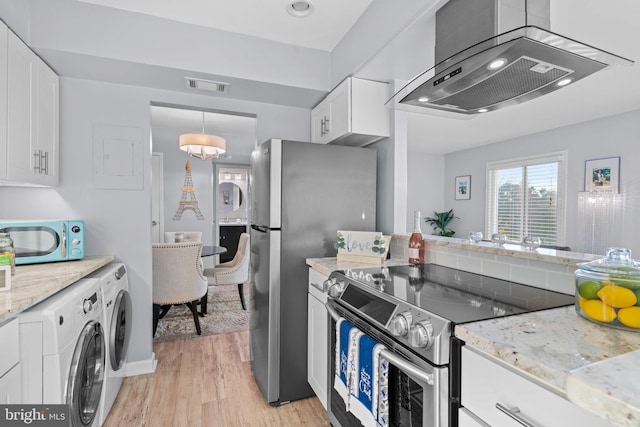 kitchen featuring appliances with stainless steel finishes, washer and clothes dryer, light wood-type flooring, and white cabinets