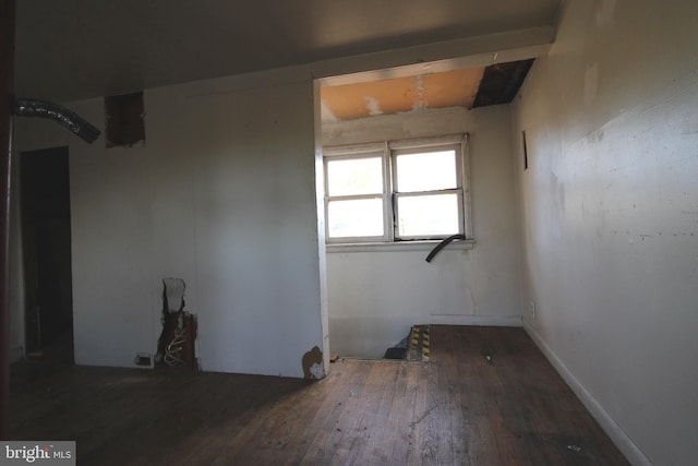 unfurnished room with dark wood-type flooring