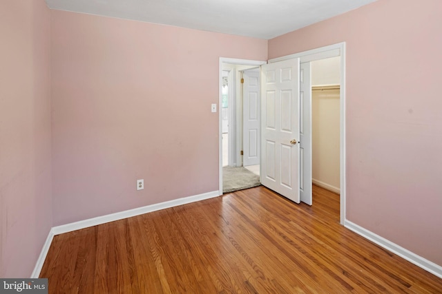 unfurnished bedroom with a closet and wood-type flooring