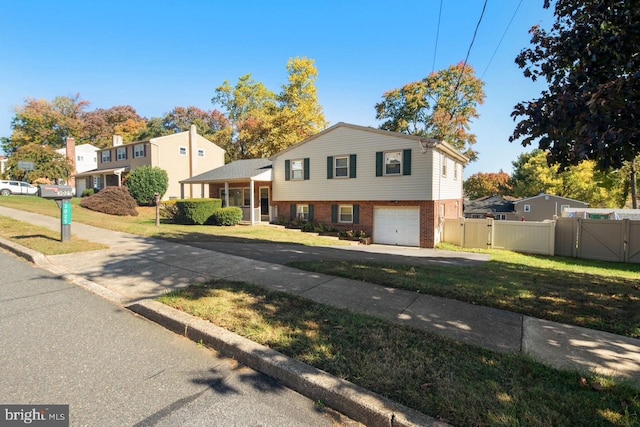 tri-level home featuring a front lawn and a garage