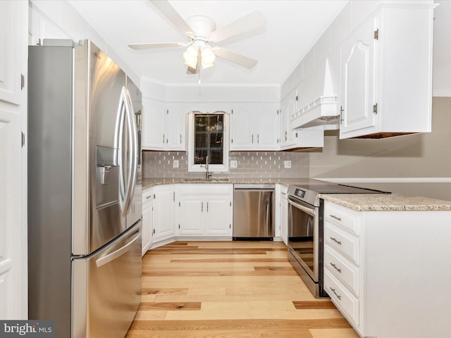 kitchen featuring appliances with stainless steel finishes, ceiling fan, sink, white cabinets, and light hardwood / wood-style floors