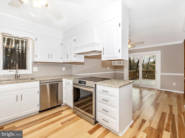 kitchen with white cabinetry, sink, light stone counters, light hardwood / wood-style flooring, and appliances with stainless steel finishes