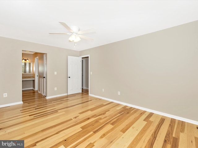 unfurnished bedroom featuring hardwood / wood-style flooring, ceiling fan, and connected bathroom