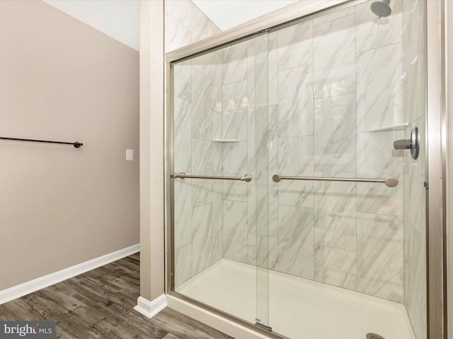 bathroom with a shower with door and wood-type flooring